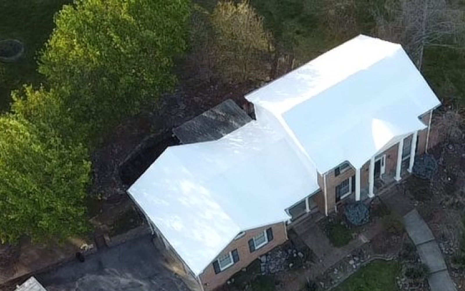 Same fire-damaged roof sealed under stretch roofing film