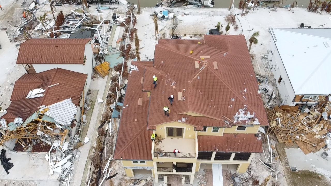 Hurricane-damaged tile roof before temporary roofing film